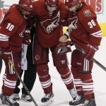 An injured Arizona Coyotes' Martin Hanzal (11), of the Czech Republic, is helped off the ice by Martin Erat (10), of the Czech Republic, and Rob Klinkhammer (36) during the second period of an NHL hockey game against the St. Louis Blues on Saturday, Oct. 18, 2014, in Glendale, Ariz. (AP Photo/Ross D. Franklin)