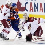 Arizona Coyotes goalie Devan Dubnyk (40) makes the save as Keith Yandle (3) and Edmonton Oilers Mark Arcobello (26) battle in front during first period NHL hockey action in Edmonton, on Sunday, Nov. 16, 2014. (AP Photo/The Canadian Press, Jason Franson)
