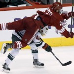 Phoenix Coyotes' Chris Summers (20) flips over Minnesota Wild's Jared Spurgeon (46) during the third period of an NHL hockey game, Saturday, March 29, 2014, in Glendale, Ariz. The Wild defeated the Coyotes 3-1. (AP Photo/Ross D. Franklin)
