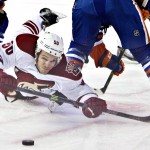 Arizona Coyotes' Antoine Vermette (50) fights for the draw against the Edmonton Oilers during the first period of an NHL hockey game in Edmonton, Alberta., on Monday, Dec. 1, 2014. (AP Photo/The Canadian Press, Jason Franson)