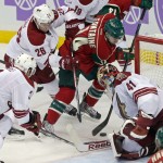 Arizona Coyotes goalie Mike Smith, right, gets some help from Keith Yandle, left, and Michael Stone as Minnesota Wild right wing Justin Fontaine tries a wrap-around shot in the third period of an NHL hockey game, Thursday, Oct. 23, 2014, in St. Paul, Minn. The Wild won 2-0. (AP Photo/Jim Mone)
