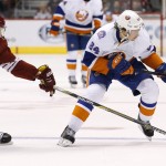 Arizona Coyotes' Connor Murphy (5) pokes the puck away from New York Islanders' Mikhail Grabovski (84) during the first period of an NHL hockey game Saturday, Nov. 8, 2014, in Glendale, Ariz. (AP Photo/Ross D. Franklin)