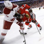 Arizona Coyotes defenseman Connor Murphy (5) and Chicago Blackhawks left wing Patrick Sharp (10) scrap for a loose puck during the first period of an NHL hockey game Tuesday, Jan. 20, 2015, in Chicago. (AP Photo/Charles Rex Arbogast)
