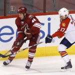 Arizona Coyotes' B.J. Crombeen (44) tries to keep the puck away from Florida Panthers' Derek MacKenzie (17) during the first period of an NHL hockey game Saturday, Oct. 25, 2014, in Glendale, Ariz. (AP Photo/Ross D. Franklin)