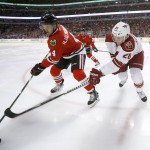 Chicago Blackhawks defenseman Niklas Hjalmarsson (4) and Arizona Coyotes left wing Lauri Korpikoski vie for a loose puck during the first period of an NHL hockey game Tuesday, Jan. 20, 2015, in Chicago. (AP Photo/Charles Rex Arbogast)
