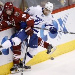Arizona Coyotes' Shane Doan (19) and Tampa Bay Lightning's Nikita Nesterov (89), of Russia, collide against the boards during the second period of an NHL hockey game Saturday, Feb. 21, 2015, in Glendale, Ariz. (AP Photo/Ross D. Franklin)
