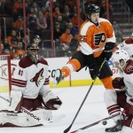 Philadelphia Flyers' Ryan White (25) center, leaps to allow the puck to go under him as Arizona Coyotes' Zbynek Michalek, (4) right, and goalie Mike Smith (41) left, defend in the second period of an NHL hockey game, Tuesday, Jan. 27, 2015, in Philadelphia. The Flyers won 4-3. (AP Photo/Tom Mihalek)