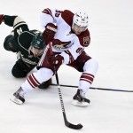 Arizona Coyotes left wing Mikkel Boedker (89), of Denmark, keeps the puck away from Minnesota Wild right wing Justin Fontaine (14) during the third period of an NHL hockey game Saturday, Jan. 17, 2015, in St. Paul, Minn. The Wild won 3-1. (AP Photo/Hannah Foslien)
