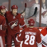 Arizona Coyotes' David Moss (18) celebrates his goal against the Carolina Hurricanes with teammates Kyle Chipchura (24) and Lauri Korpikoski (28), of Finland, as Hurricanes' Alexander Semin, right, of Russia, skates away during the first period of an NHL hockey game Thursday, Feb. 5, 2015, in Glendale, Ariz. (AP Photo/Ross D. Franklin)