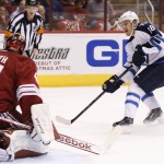 Winnipeg Jets' Bryan Little (18) scores a goal against Arizona Coyotes' Mike Smith (41) during the first period of an NHL hockey game Thursday, Oct. 9, 2014, in Glendale, Ariz. (AP Photo/Ross D. Franklin)