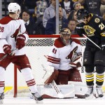 Arizona Coyotes goalie Mike Smith makes a save with Boston Bruins' Loui Eriksson (21) in front and defenseman Michael Stone (26) looking on during the first period of an NHL hockey game in Boston Saturday, Feb. 28, 2015. (AP Photo/Winslow Townson)