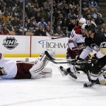 Pittsburgh Penguins' Craig Adams (27) can't lift the puck over a sprawling Phoenix Coyotes goalie Thomas Greiss (1) during the second period of an NHL hockey game in Pittsburgh, Tuesday, March 25, 2014. (AP Photo/Gene J. Puskar)
