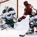 Minnesota Wild's Ilya Bryzgalov, left, of Russia, makes a save on a shot by Phoenix Coyotes' Martin Hanzal (11), of the Czech Republic, as Wild's Jared Spurgeon, right, defends during the second period of an NHL hockey game, Saturday, March 29, 2014, in Glendale, Ariz. (AP Photo/Ross D. Franklin)