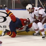 Florida Panthers' Tomas Fleischmann and Arizona Coyotes' Zbynek Mikchalek (4) battle for the puck during the first period of an NHL hockey game in Sunrise, Fla., Thursday, Oct. 30, 2014. (AP Photo/J Pat Carter)
