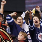 Winnipeg Jets fans celebrate a goal against the Arizona Coyotes during the first period of an NHL hockey game Thursday, Oct. 9, 2014, in Glendale, Ariz. (AP Photo/Ross D. Franklin)