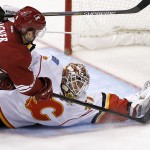 Calgary Flames' Joni Ortio, right, of Finland, makes a save on a shot by Arizona Coyotes' Sam Gagner (9) during the first period of an NHL hockey game Thursday, Jan. 15, 2015, in Glendale, Ariz. (AP Photo/Ross D. Franklin)