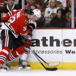 Chicago Blackhawks defenseman Michal Rozsival and Arizona Coyotes left wing Lauri Korpikoski (28) vie for a loose puck during the first period of an NHL hockey game Tuesday, Jan. 20, 2015, in Chicago. (AP Photo/Charles Rex Arbogast)
