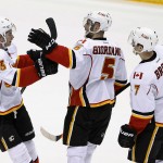 Calgary Flames' Mark Giordano (5) celebrates his goal against the Arizona Coyotes with teammates Sean Monahan (23) and T.J. Brodie (7) during the third period of an NHL hockey game Thursday, Jan. 15, 2015, in Glendale, Ariz. The Flames defeated the Coyotes 4-1. (AP Photo/Ross D. Franklin)