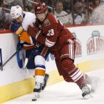 Arizona Coyotes' Oliver Ekman-Larsson (23), of Sweden, checks New York Islanders' Casey Cizikas (53) into the boards during the first period of an NHL hockey game Saturday, Nov. 8, 2014, in Glendale, Ariz. (AP Photo/Ross D. Franklin)
