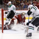 Arizona Coyotes' Mike Smith (41) makes a sliding save on a shot by Dallas Stars' Patrick Eaves, right, as Stars' Jamie Benn (14) looks on during the first period of an NHL hockey game Tuesday, Nov. 11, 2014, in Glendale, Ariz. (AP Photo/Ross D. Franklin)