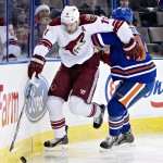 Arizona Coyotes' Martin Hanzal (11) is checked by Edmonton Oilers' Oscar Klefbom (84) during the first period of an NHL hockey game in Edmonton, Alberta., on Monday, Dec. 1, 2014. (AP Photo/The Canadian Press, Jason Franson)
