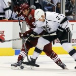 Arizona Coyotes center Kyle Chipchura (24) and Los Angeles Kings defenseman Matt Greene (2) battle for the puck in the first period during an NHL hockey game, Thursday, Dec. 4, 2014, in Glendale, Ariz. (AP Photo/Rick Scuteri)