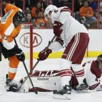 Philadelphia Flyers' Wayne Simmonds (17), left, and Arizona Coyotes' Connor Murphy (5) right, dig for the loose puck near Simmonds left skate while goalie Mike Smith watches in the second period of an NHL hockey game, Tuesday, Jan. 27, 2015, in Philadelphia. The Flyers won 4-3. (AP Photo/Tom Mihalek)