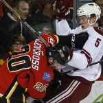 Arizona Coyotes' Connor Murphy, right, and Calgary Flames' Curtis Glencross collide during the first period of an NHL hockey game Thursday, Nov. 13, 2014, in Calgary, Alberta. (AP Photo/The Canadian Press, Jeff McIntosh)