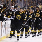 Boston Bruins' Brad Marchand is congratulated at the bench after scoring against the Arizona Coyotes during the first period of an NHL hockey game in Boston Saturday, Feb. 28, 2015. (AP Photo/Winslow Townson)
