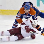 Arizona Coyotes Tobias Rieder (8) is knocked down by Edmonton Oilers Nikita Nikitin (86) while battling for the puck during the third period of an NHL hockey game in Edmonton, Alberta, on Sunday, Nov. 16, 2014. (AP Photo/The Canadian Press, Jason Franson)