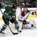 Dallas Stars center Cody Eakin (20) attempts to gain control of the puck as Arizona Coyotes' Mike Smith (41) defend the net in the first period of an NHL hockey game, Thursday, Nov. 20, 2014, in Dallas. (AP Photo/Tony Gutierrez)