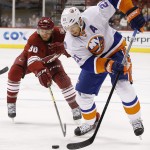 New York Islanders' Kyle Okposo (21) tries to keep the puck away from Arizona Coyotes' Rob Klinkhammer (36) during the first period of an NHL hockey game Saturday, Nov. 8, 2014, in Glendale, Ariz. (AP Photo/Ross D. Franklin)