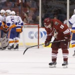 Arizona Coyotes' Shane Doan (19) skates off the ice as New York Islanders' Brian Strait (37), Nikolai Kulemin (86), Frans Nielsen (51), Nick Leddy (2) and other players celebrate a win at the end of an NHL hockey game Saturday, Nov. 8, 2014, in Glendale, Ariz. The Islanders defeated the Coyotes 1-0. (AP Photo/Ross D. Franklin)