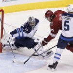 Arizona Coyotes' Martin Hanzal (11), of the Czech Republic, scores a goal against Winnipeg Jets' Ondrej Pavelec, left, of the Czech Republic, as Jets' Mark Stuart (5) defends during the third period of an NHL hockey game Thursday, Oct. 9, 2014, in Glendale, Ariz. The Jets defeated the Coyotes 6-2. (AP Photo/Ross D. Franklin)