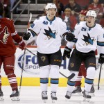 San Jose Sharks' Tomas Hertl (48), of the Czech Republic, smiles as he celebrates his goal with teammate Tye McGinn (25) as Arizona Coyotes' Michael Stone (26) skates away and Coyotes' Keith Yandle, right, watches during the second period of an NHL hockey game Tuesday, Jan. 13, 2015, in Glendale, Ariz. The Sharks won 3-2. (AP Photo/Ross D. Franklin)