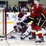  Arizona Coyotes goalie Mike McKenna, left, tracks the puck as Calgary Flames Joe Colborne tries for a rebound during the first period of an NHL preseason hockey game in Sylvan Lake, Alberta, Wednesday, Sept. 24, 2014. (AP Photo/The Canadian Press, Jeff McIntosh)