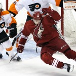 Philadelphia Flyers' Claude Giroux (28) checks Arizona Coyotes' Antoine Vermette (50) into the air during the first period of an NHL hockey game Monday, Dec. 29, 2014, in Glendale, Ariz. (AP Photo/Ross D. Franklin)
