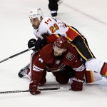 Arizona Coyotes' Joe Vitale (14) and Calgary Flames' Deryk Engelland (29) collide during the third period of an NHL hockey game Thursday, Jan. 15, 2015, in Glendale, Ariz. The Flames defeated the Coyotes 4-1. (AP Photo/Ross D. Franklin)