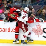 Ottawa Senators' Mark Stone (61) is checked by Arizona Coyotes' Oliver Ekman-Larsson (23) during the first period of an NHL hockey game in Ottawa, Ontario, Saturday, Jan. 31, 2015. (AP Photo/The Canadian Press, Fred Chartrand)
