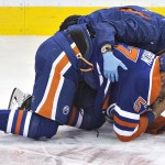 Edmonton Oilers' David Perron (57) is injured after a hit from the Arizona Coyotes during the second period of an NHL hockey preseason game, Wednesday, Oct. 1, 2014, in Edmonton, Alberta. (AP Photo/The Canadian Press, Jason Franson)