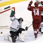 Dallas Stars' Tim Thomas, left, slams his stick down to the ice as Phoenix Coyotes' Jeff Halpern (14) celebrates a goal by teammate David Moss during the third period of an NHL hockey game on Sunday, April 13, 2014, in Glendale, Ariz. The Coyotes defeated the Stars 2-1. (AP Photo/Ross D. Franklin)