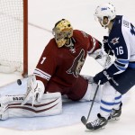 Winnipeg Jets' Andrew Ladd (16) scores against Phoenix Coyotes' Thomas Greiss (1), of Germany, during a shootout in an NHL hockey game, Tuesday, April 1, 2014, in Glendale, Ariz. The Jets defeated the Coyotes in a shootout 2-1. (AP Photo/Ross D. Franklin)