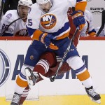 New York Islanders' Cal Clutterbuck (15) sends Arizona Coyotes' Tobias Rieder to the ice during the first period of an NHL hockey game Saturday, Nov. 8, 2014, in Glendale, Ariz. (AP Photo/Ross D. Franklin)