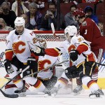 A shot by Arizona Coyotes' Mikkel Boedker, of Denmark, gets past Calgary Flames' Raphael Diaz (33), of Switzerland; Deryk Engelland (29) and goalie Joni Ortio, second from left, for a goal as Coyotes' Tobias Rieder (8), of Germany, watches during the second period of an NHL hockey game Thursday, Jan. 15, 2015, in Glendale, Ariz. (AP Photo/Ross D. Franklin)