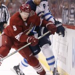Arizona Coyotes' Connor Murphy (5) checks Winnipeg Jets' Blake Wheeler (26) into the boards during the first period of an NHL hockey game Thursday, Oct. 9, 2014, in Glendale, Ariz. (AP Photo/Ross D. Franklin)