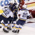 St. Louis Blues' Kevin Shattenkirk (22), Alexander Steen (20) and Jaden Schwartz celebrate a goal scored by St. Louis Blues' David Backes, second from left, as Arizona Coyotes' Mike Smith, right, tries to get up off the ice during the first period of an NHL hockey game Saturday, Oct. 18, 2014, in Glendale, Ariz. (AP Photo/Ross D. Franklin)