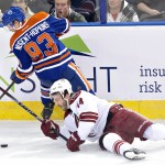 Arizona Coyotes Joe Vitale (14) and Edmonton Oilers Ryan Nugent-Hopkins (93) battle for the puck during second period NHL hockey action in Edmonton, on Sunday, Nov. 16, 2014. (AP Photo/The Canadian Press, Jason Franson)