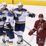 St. Louis Blues' Alexander Steen (20) celebrates his goal with teammates Jordan Leopold (33), Barret Jackman (5) and Vladimir Tarasenko (91), of Russia, as Arizona Coyotes' Keith Yandle (3) skates past during the second period of an NHL hockey game Saturday, Oct. 18, 2014, in Glendale, Ariz. (AP Photo/Ross D. Franklin)