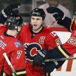 Calgary Flames Mark Giordano, center, celebrates his goal with teammates TJ Brodie, left, and Sean Monahan during the second period of an NHL hockey game against the Arizona Coyotes in Calgary, Alberta, Thursday, Nov. 13, 2014. (AP Photo/The Canadian Press, Jeff McIntosh)