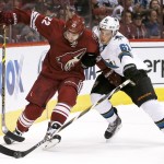 San Jose Sharks' Justin Braun (61) slaps the puck away from Arizona Coyotes' Brandon McMillan (22) during the second period of an NHL hockey game Tuesday, Jan. 13, 2015, in Glendale, Ariz. The Sharks won 3-2. (AP Photo/Ross D. Franklin)